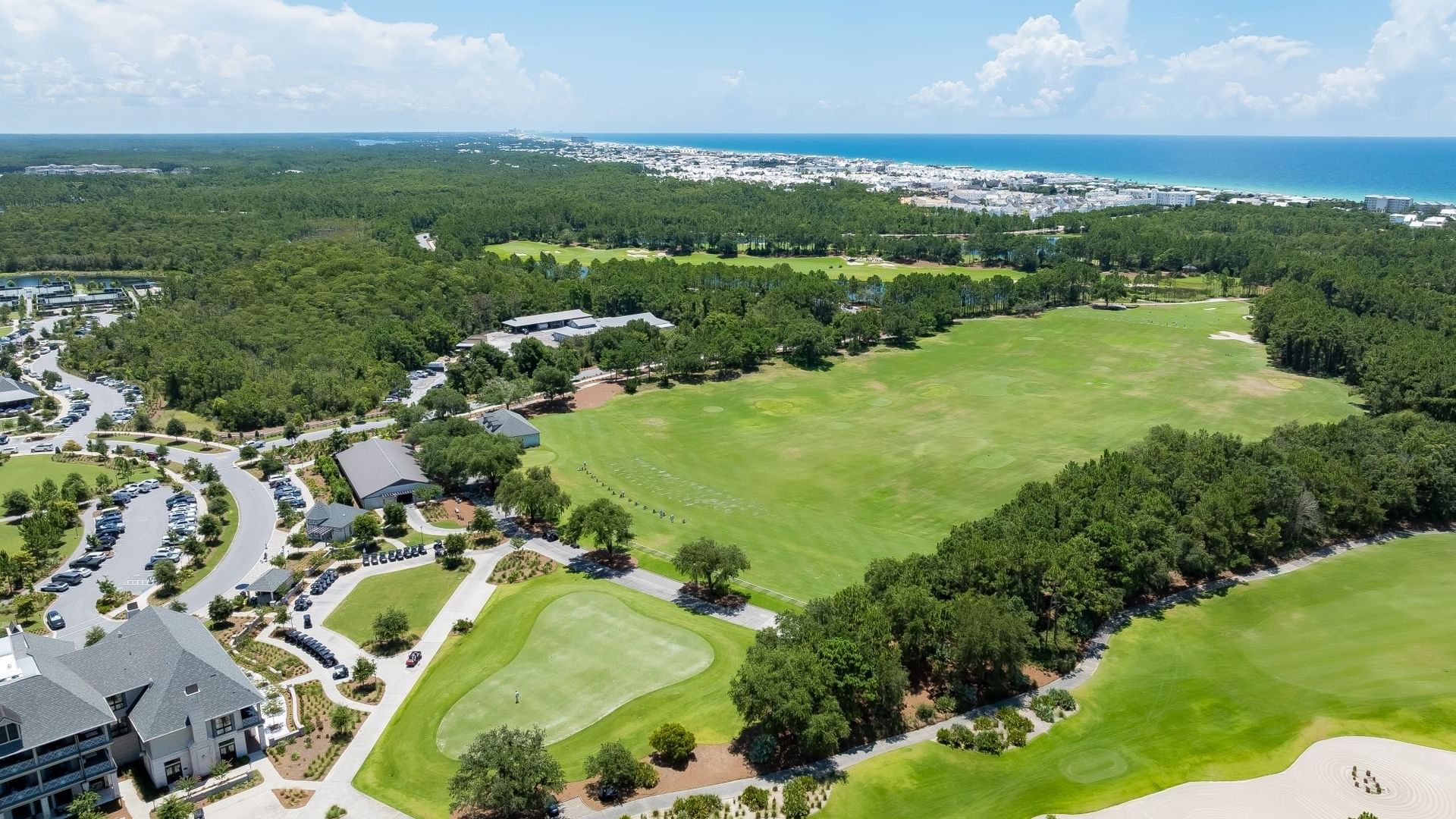 Aerial view of the Camp Creek Driving Range with lush green fairways and coastal scenery at Camp Creek Inn in Inlet Beach.