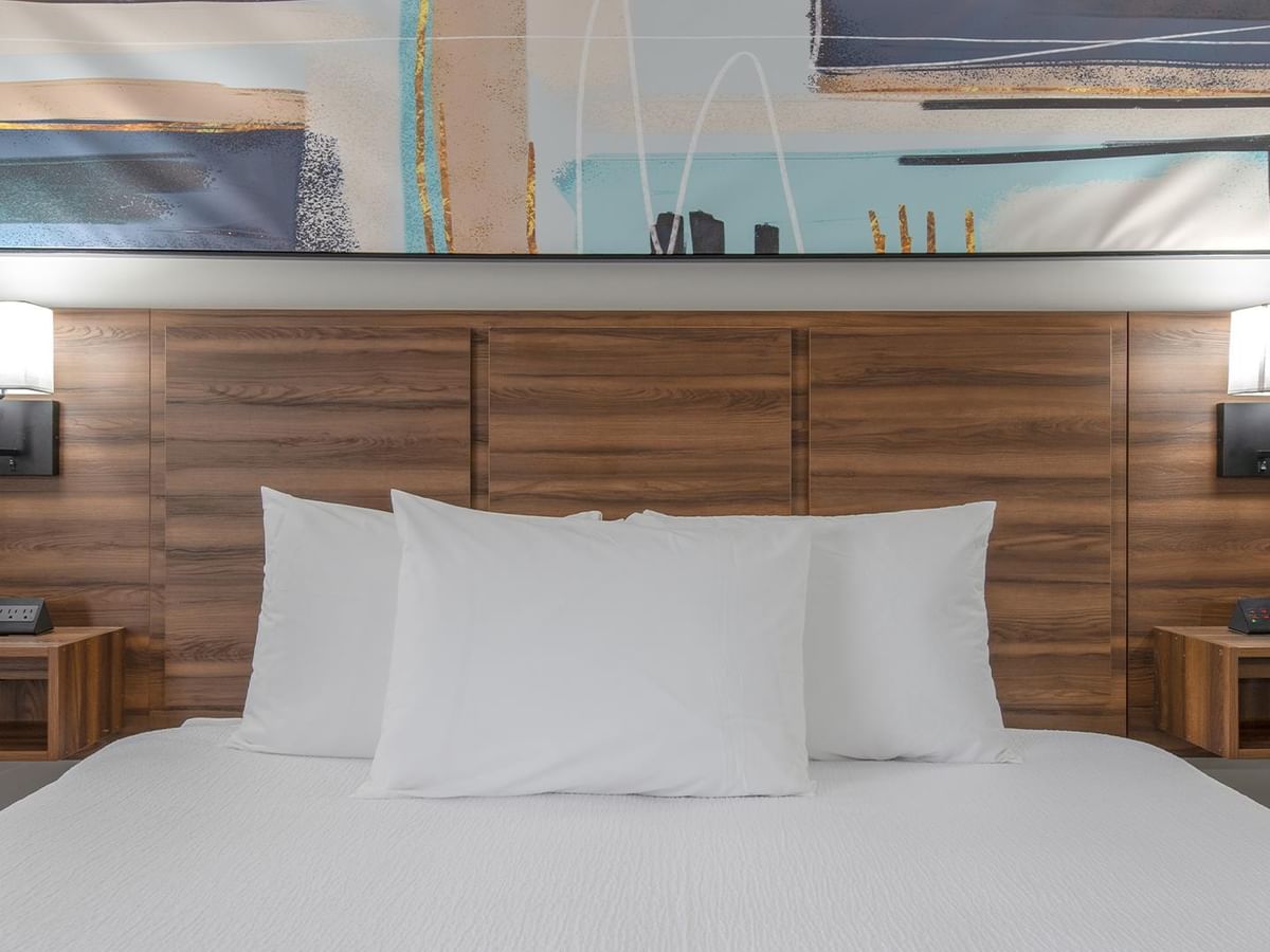 King bed with wooden headboard and modern decor at Coast Dawson Creek Hotel.