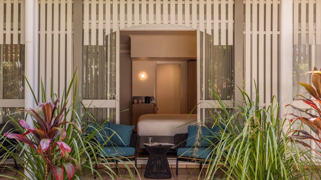 Deluxe room with private patio, teal seating, tropical plants, and modern decor at Novotel Sunshine Coast Twin Waters