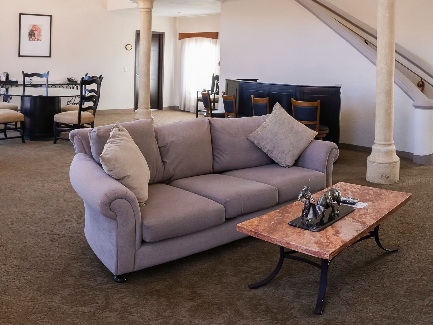 Spacious suite with gray sofa, dining area, and colonial architectural details at Quinta Real Zacatecas