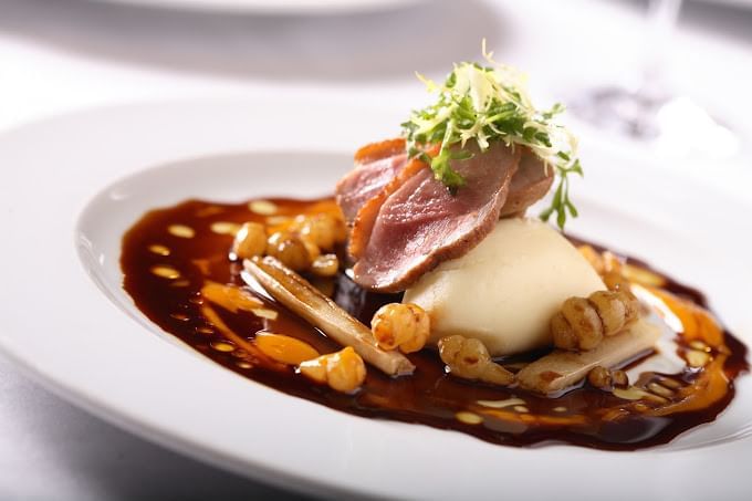 Close-up of a beef dish served in Araxi Restaurant + Oyster Bar at Blackcomb Springs Suites