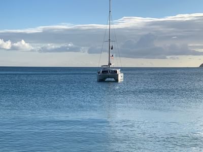White catamaran yacht floating on calm blue ocean waters under a cloudy sky at Emerald Beach Resort