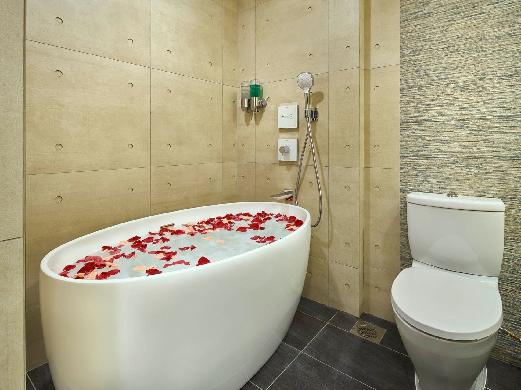 Image 59: Luxurious One Bedroom Premier bathroom with an oval tub and rose petals, beside a white toilet at Orchard Grand Court