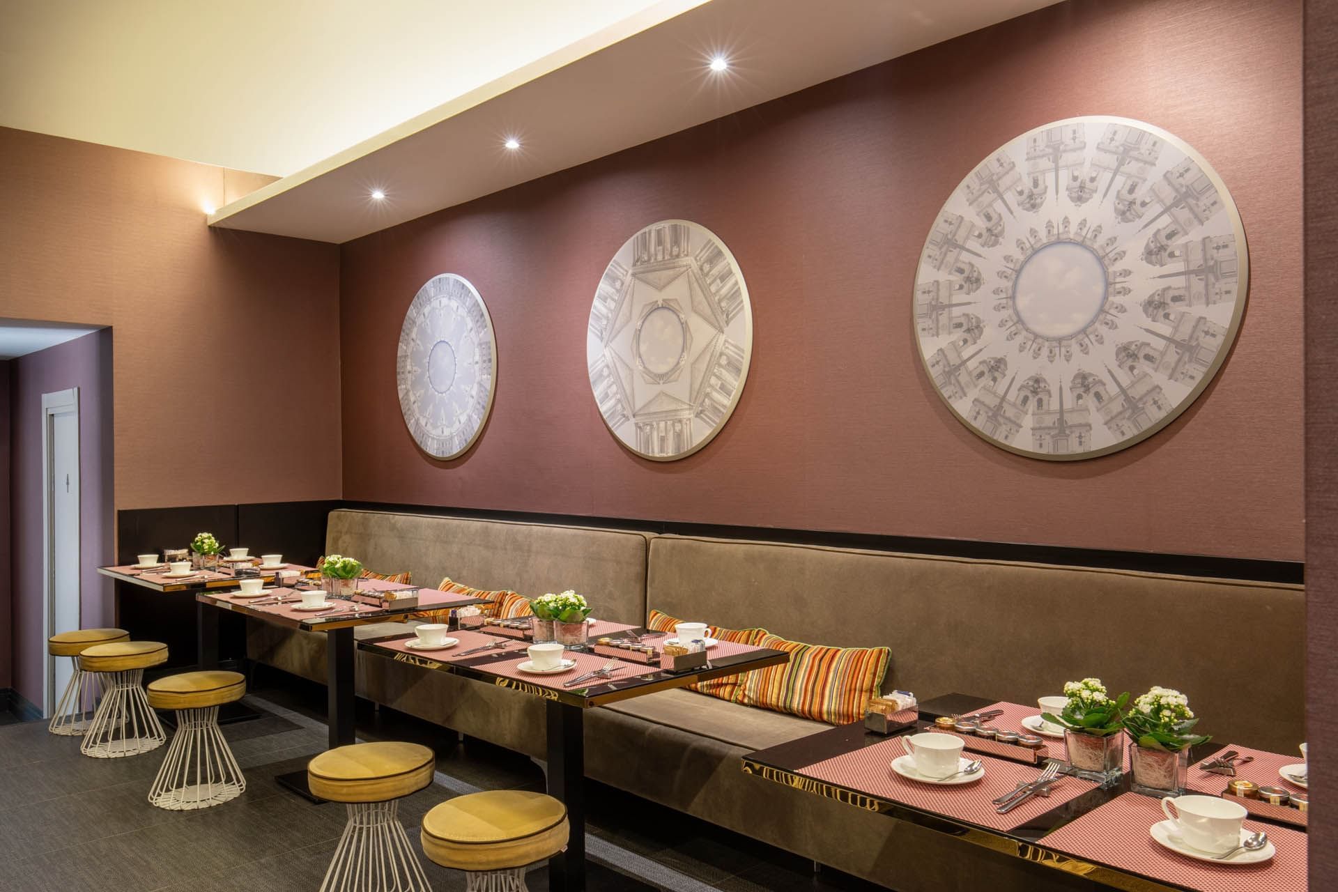 Cozy Breakfast restaurant at The Guardian Hotel with striped cushions, elegant table settings, and artwork