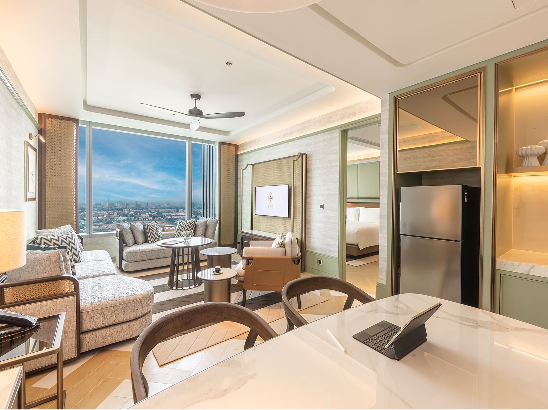 Dining table & living area with TV in 2 Bedroom Suite at Eastin Grand Hotel Phayathai