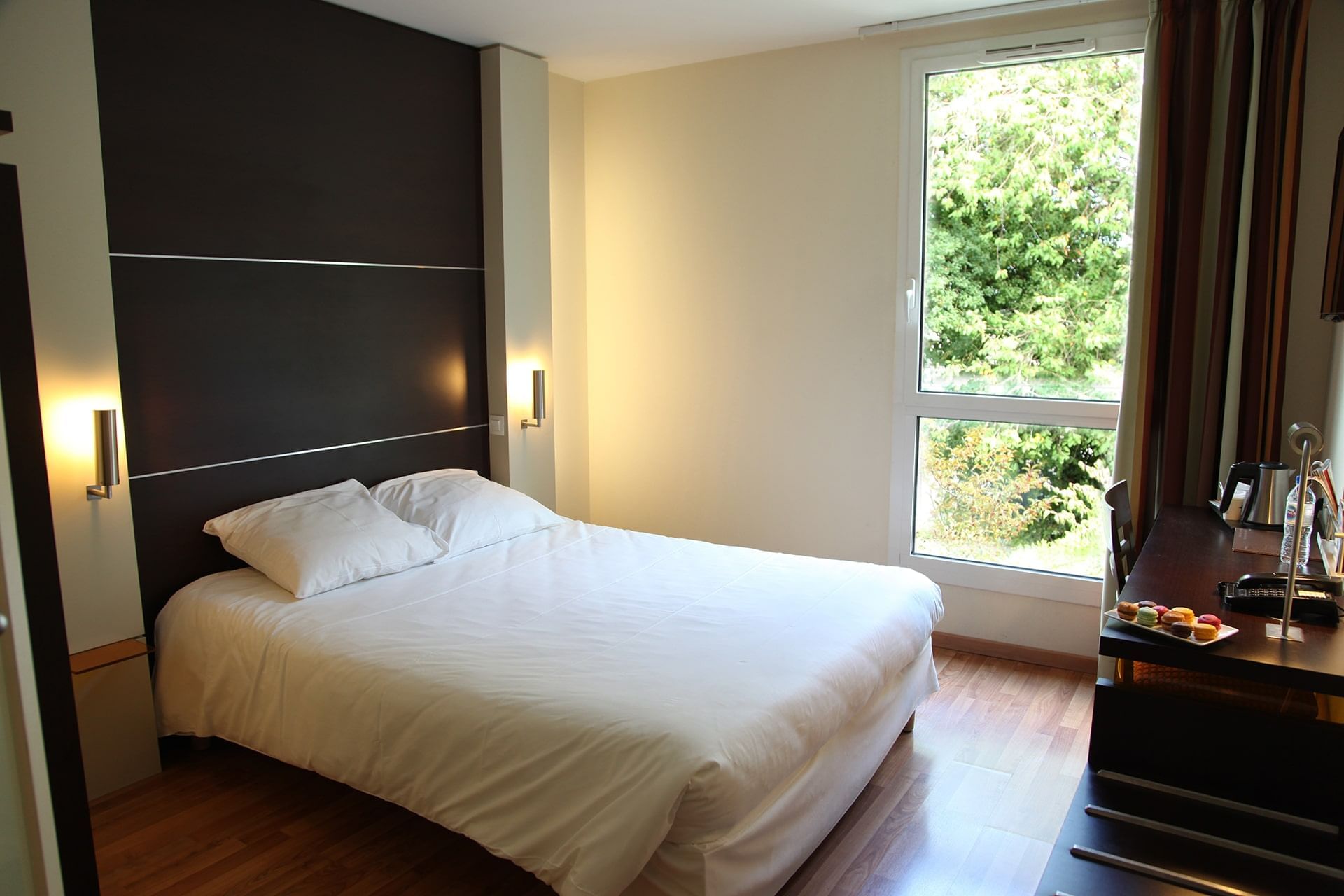 Lit king-size et bureau dans une chambre à l'Escale Oceania Rennes