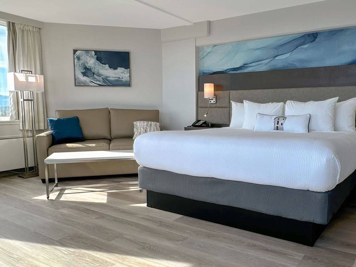 Hotel guestroom with king bed, a sofa and coffee table
