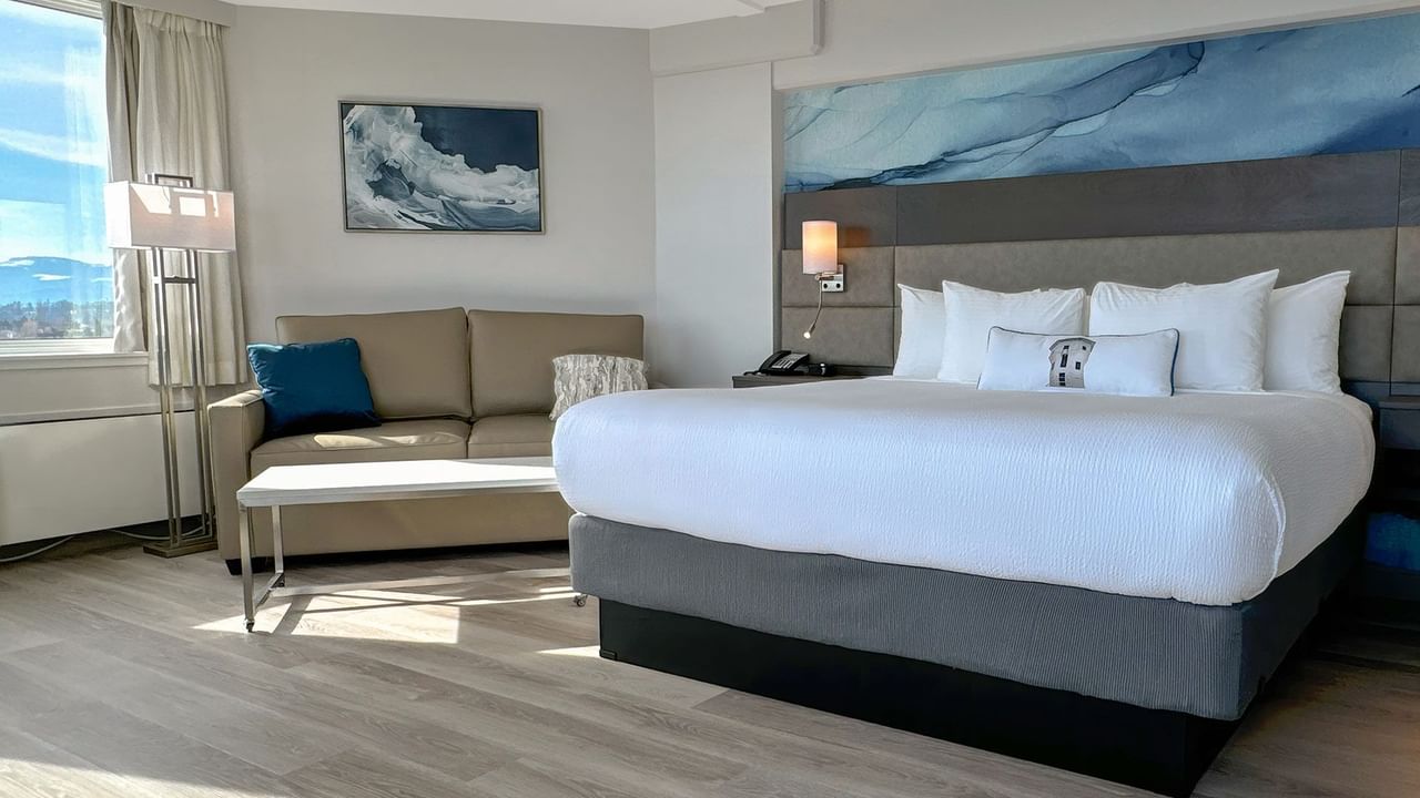 Hotel guestroom with king bed, a sofa and coffee table