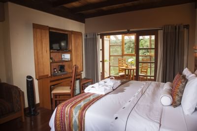 suite with bed, desk and small dining table in patio