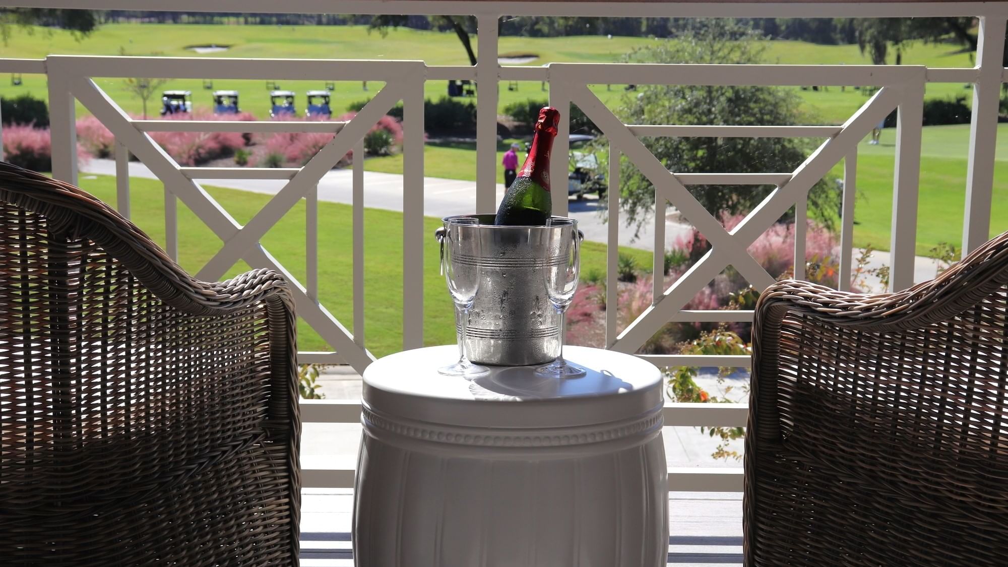A champagne bucket and glasses sits on a table on a balcony at Camp Creek Inn
