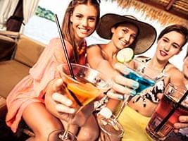 3 women holding cocktail glasses & enjoying at Cruisin Tikis Key Largo near Bayside Inn Key Largo