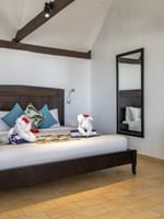 Comfortable Beach Front Bure room with a bed and amenities at Tambua Sands Beach Resort in Sigatoka.