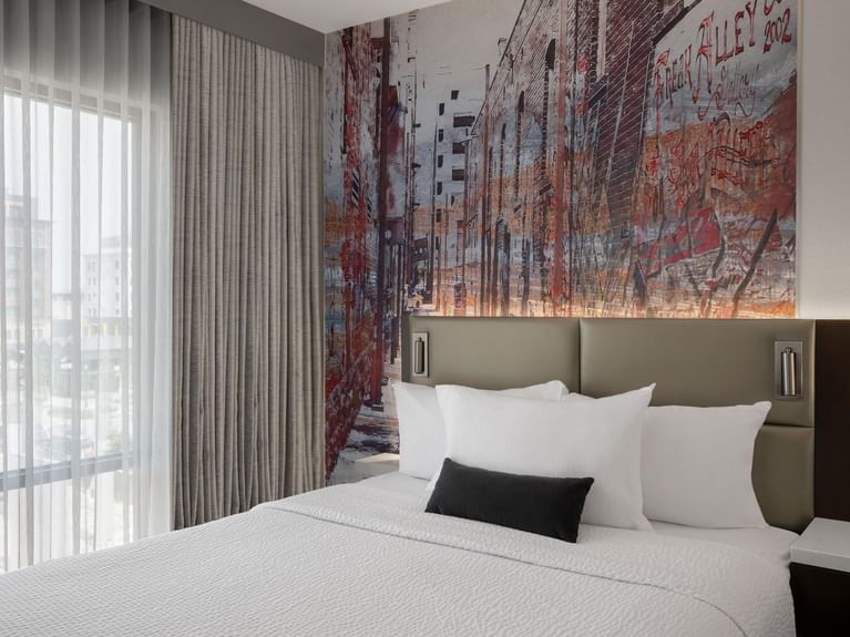 Boutique Double Queen room with a mural of a graffiti-covered alley on the wall above the bed at Hotel 43 Boise