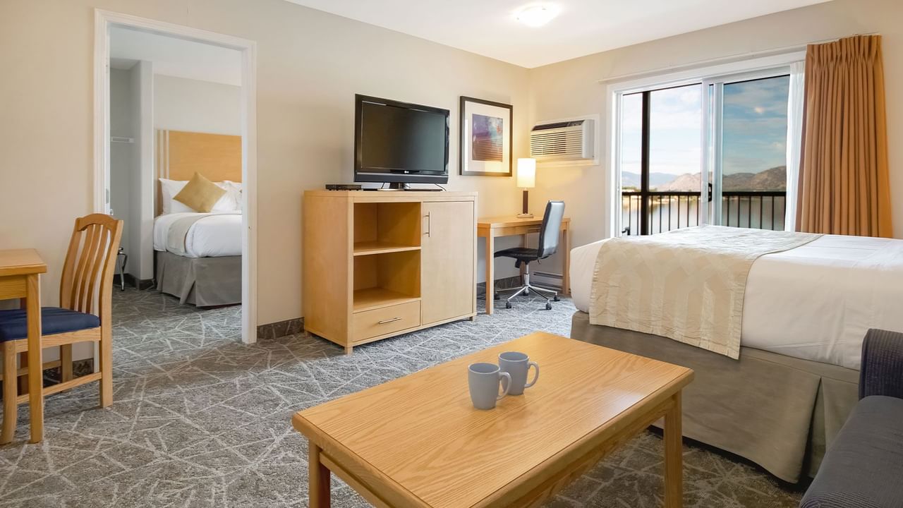Spacious suite featuring two queen beds, a cozy seating area and lake views from the balcony.