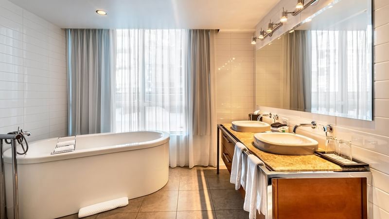 Bathroom area with mirror & bathtub in Penthouse Suite Sainte-Catherine at Warwick Le Crystal 