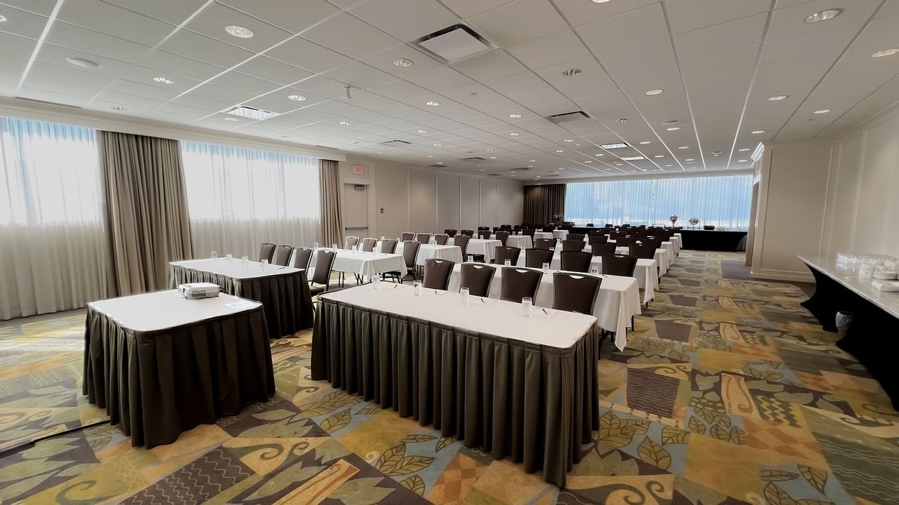 Rows of set tables facing same direction with chairs
