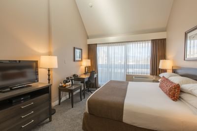Traditional Room with a King sized bed, a TV and bright lighting at Embassy Inn Victoria