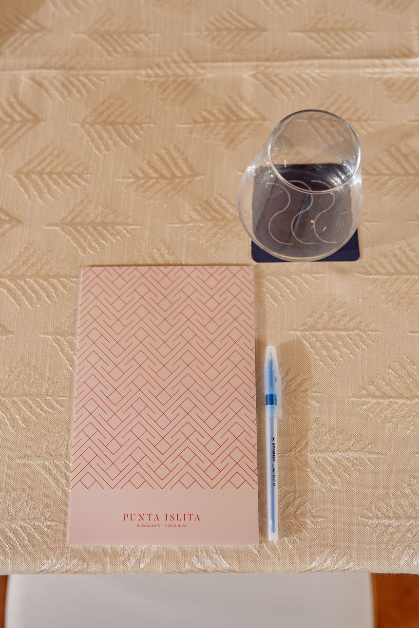 Book, pen & empty glass on the table at Punta Islita Hotel