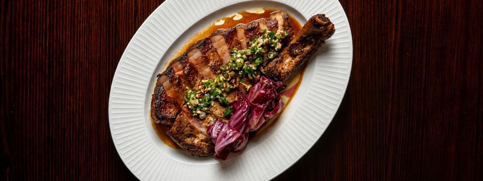 Grilled steak with herb topping and pickled onions on a white plate for NRL Grand Final Dining
