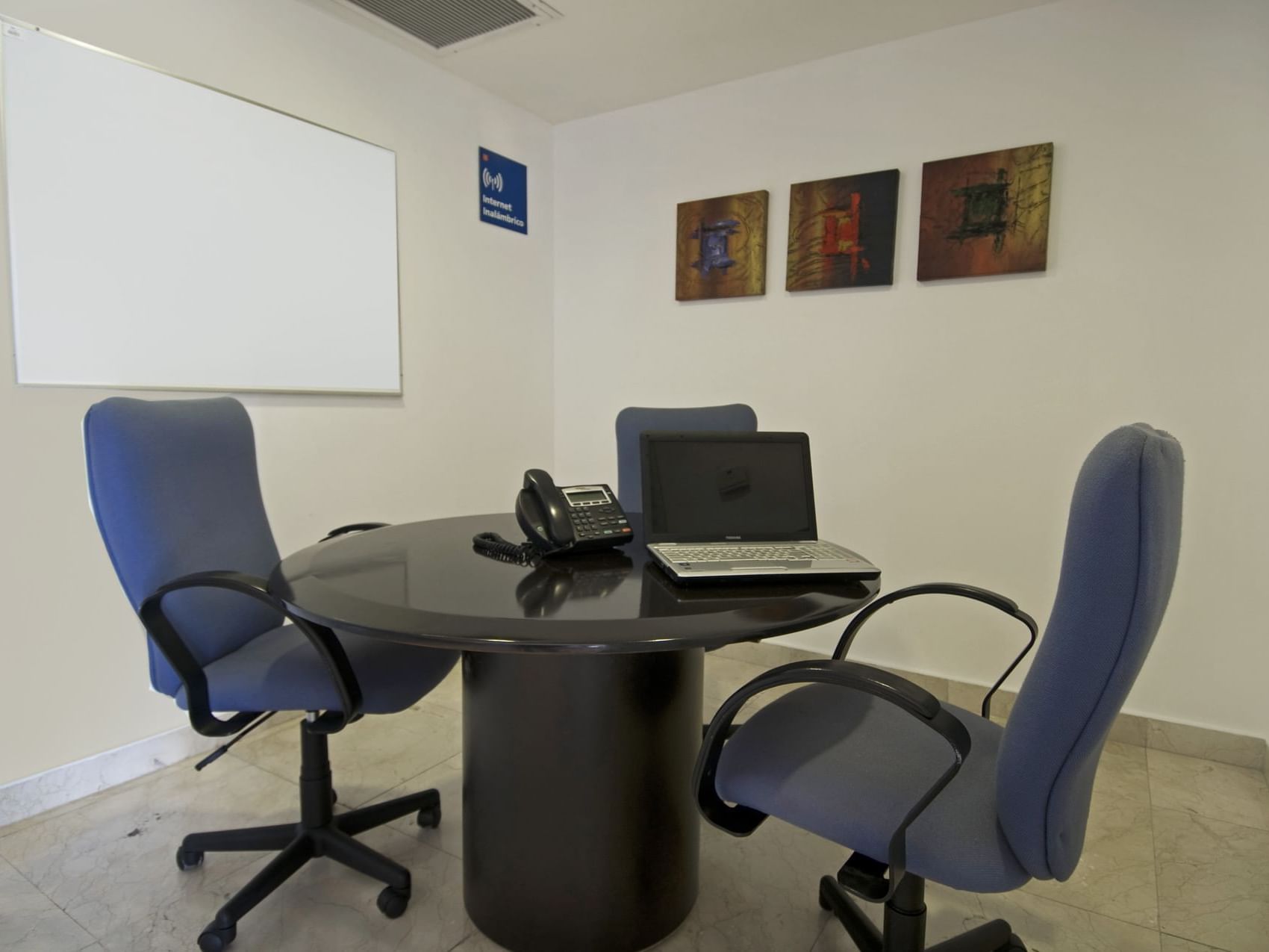 Round table with 2 comfy chairs in a meeting room at One Hotels