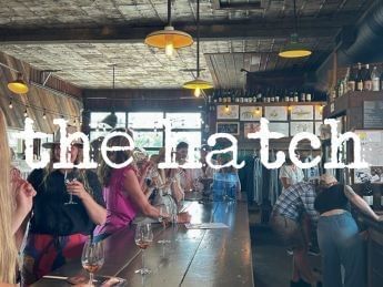People enjoying drinks at a bustling winery called the hatch.