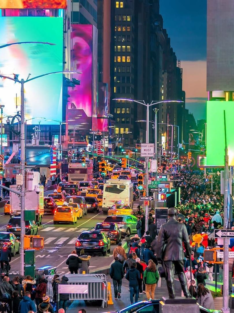 Crowded Times Square at dusk with bright digital billboards and heavy traffic near Warwick New York