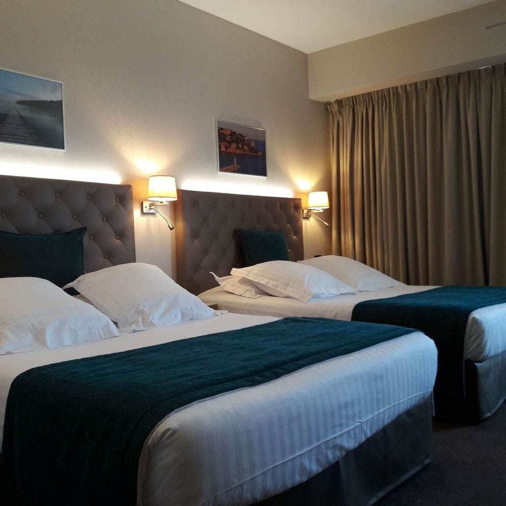 Family Room with plush twin beds, teal runners, and framed scenic wall decor at Splendid Hotel & Spa Nice