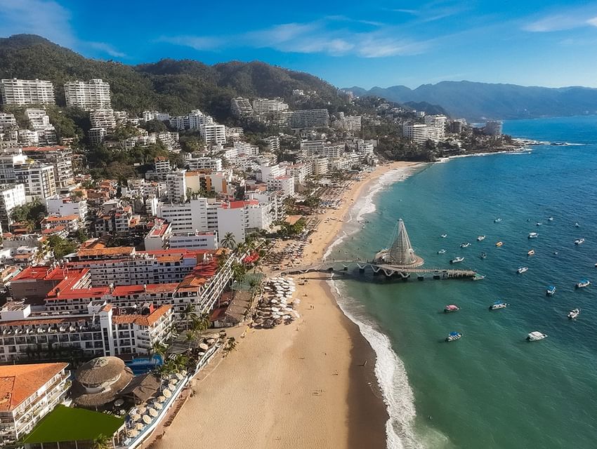 Aerial view of Los Muertos Pier with boats on blue ocean water along the beach front near Casa Dona Susana