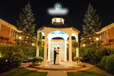 Wedding couple hugging at exterior gazebo at Ethan Allen Hotel