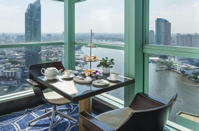 Tea table by a window at Club Lounge in Chatrium Hotel