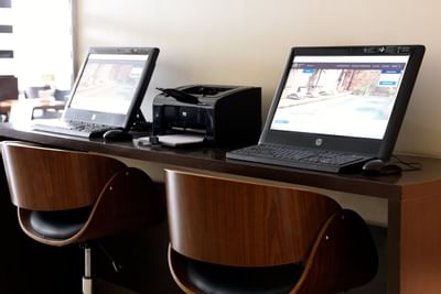 Computadoras portátiles e impresora en una mesa en Argenta Suites Belgrano