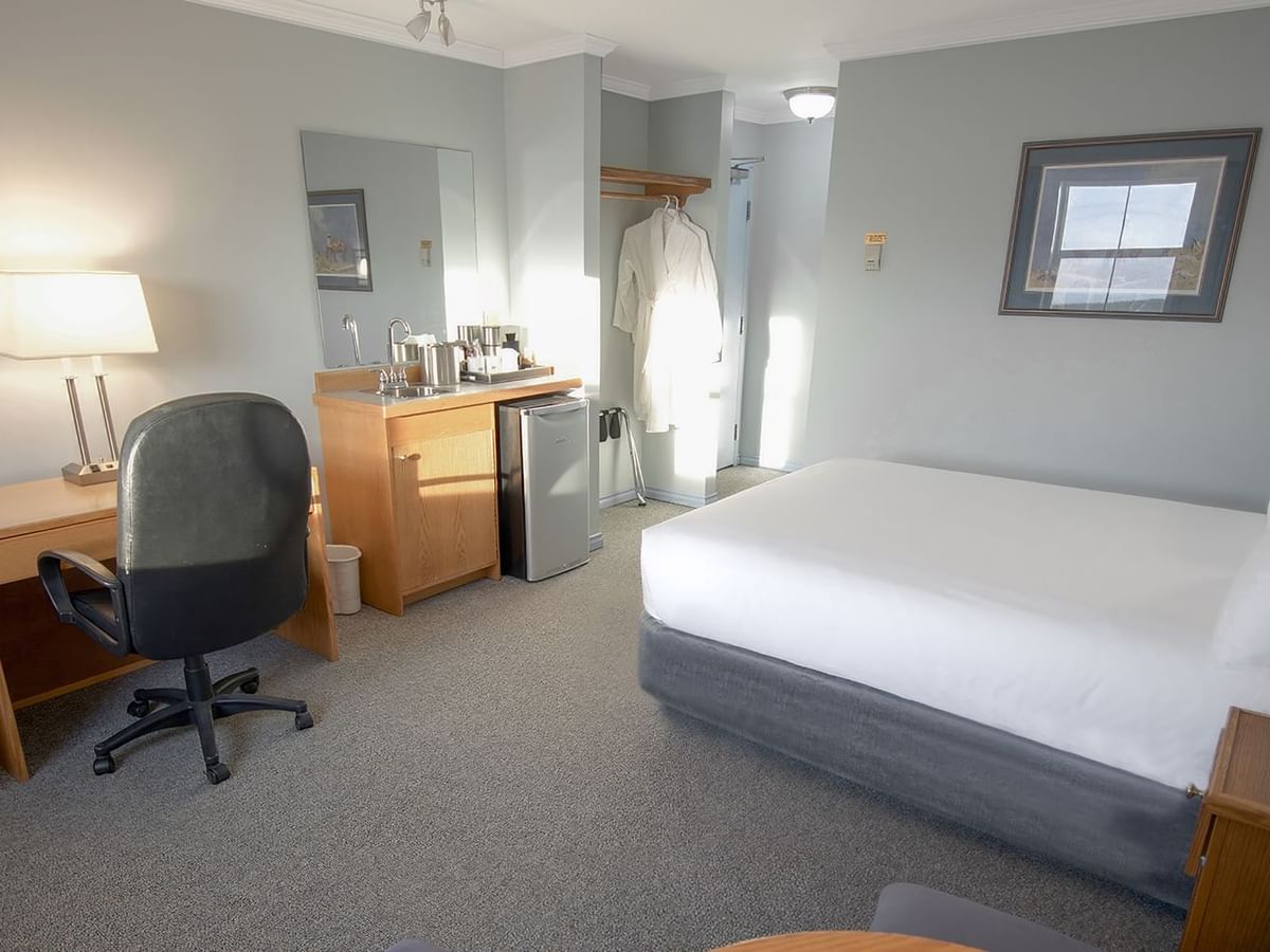 queen bed, with a work desk, and a mini fridge