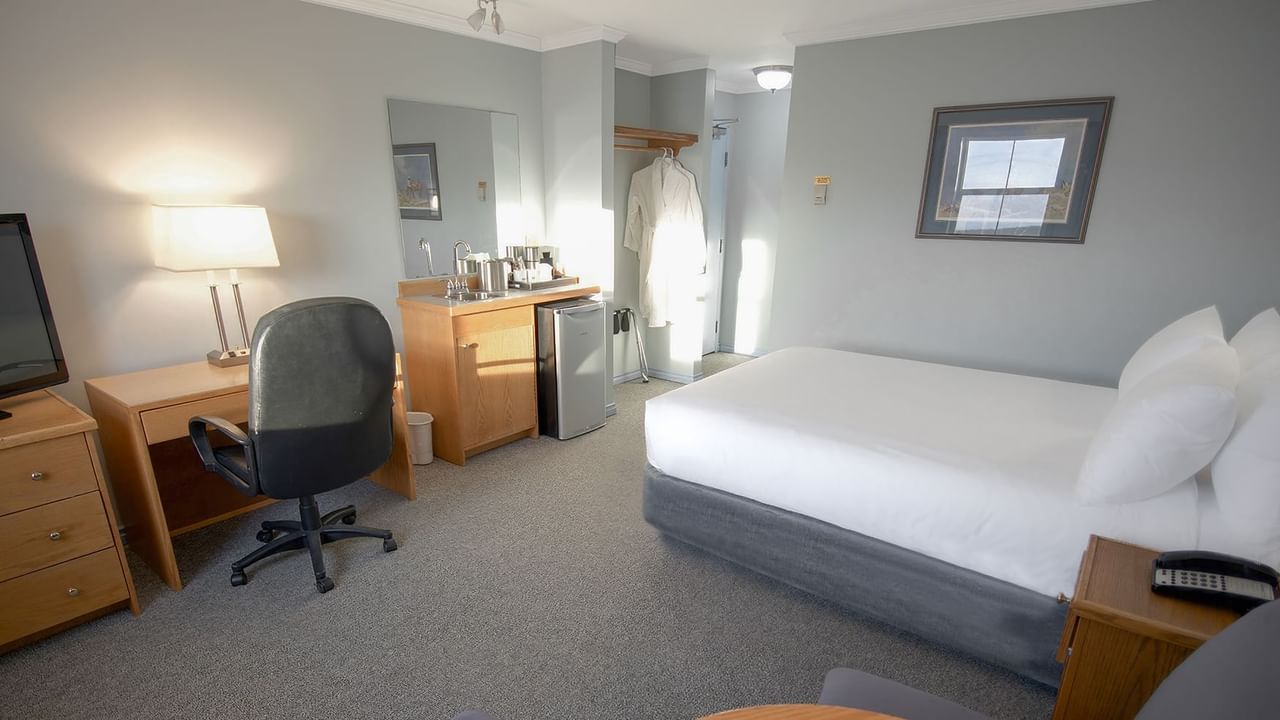 queen bed, with a work desk, and a mini fridge