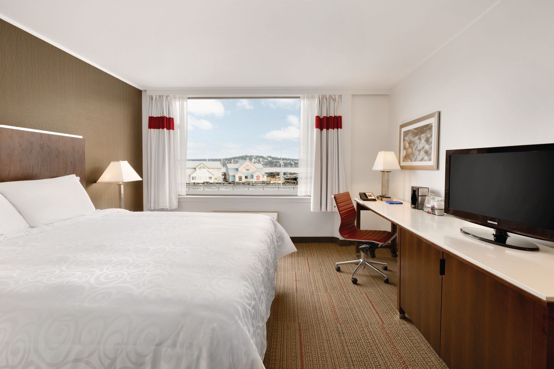 Bed and TV in hotel room with window