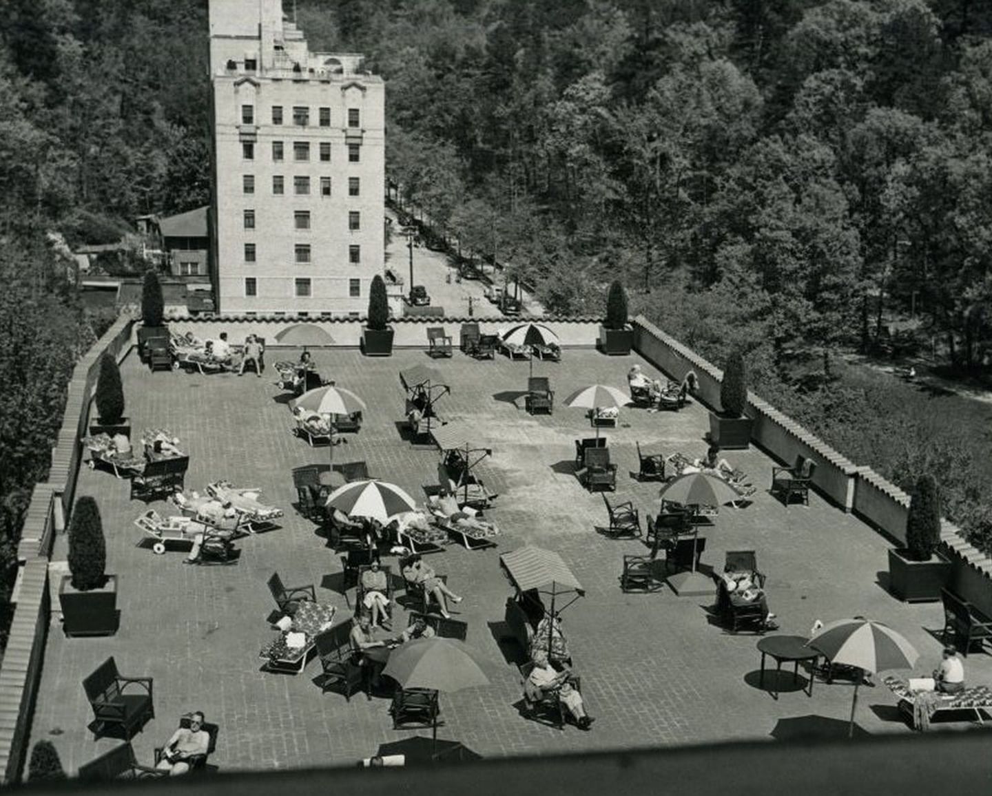 Black and white rooftop view with guests by umbrellas surrounding the deck at Arlington Resort Hotel & Spa