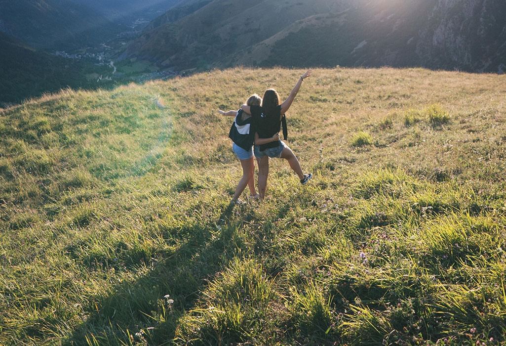 girlfriends walking through mountain field together