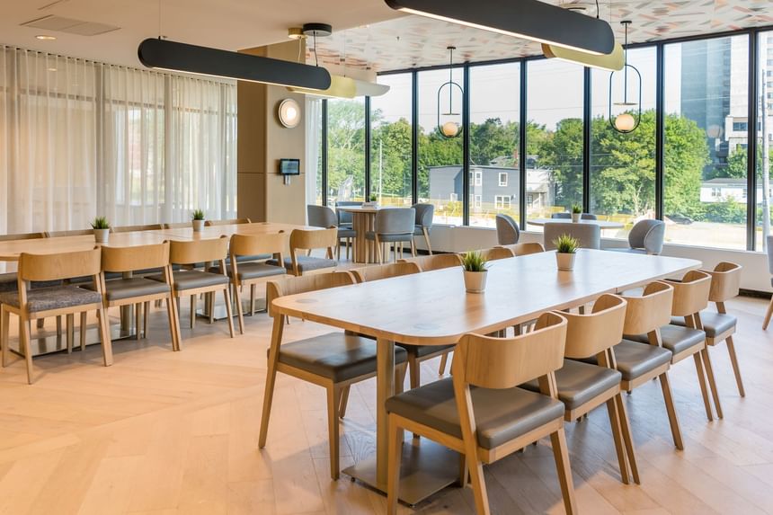 Modern dining area at The Cannery Restaurant with wooden tables, cushioned chairs, large windows