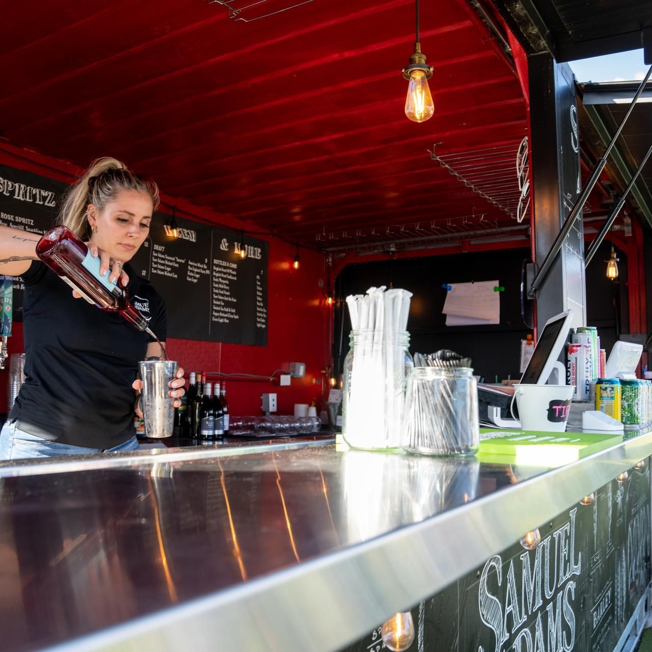 Bartendress making a drink in Beer Garden at The Artisan Hotel at Tuscan Village
