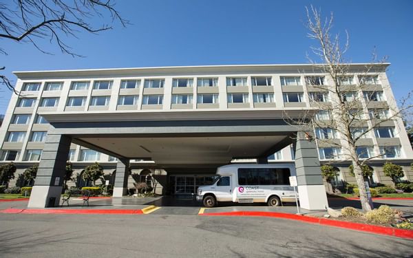 Airport shuttle at Coast Gateway Hotel's canopy about to bring g