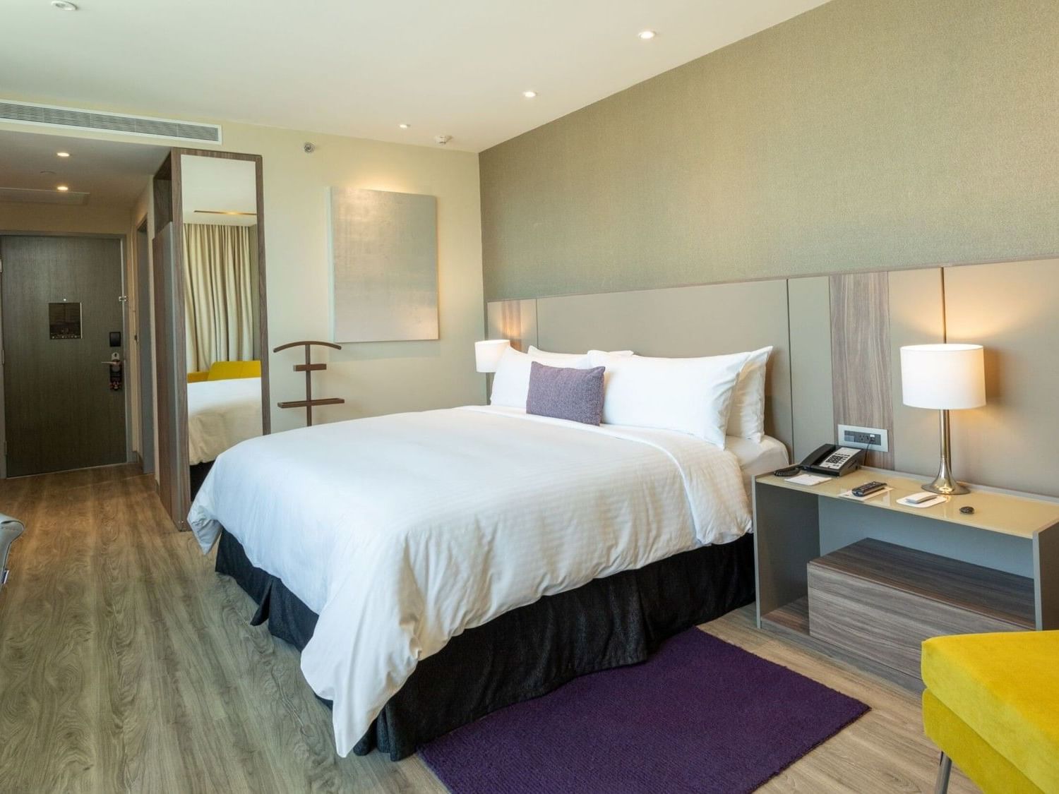King Junior Suite with modern furnishings and yellow accent chairs at Camino Real Fashion Drive Monterrey