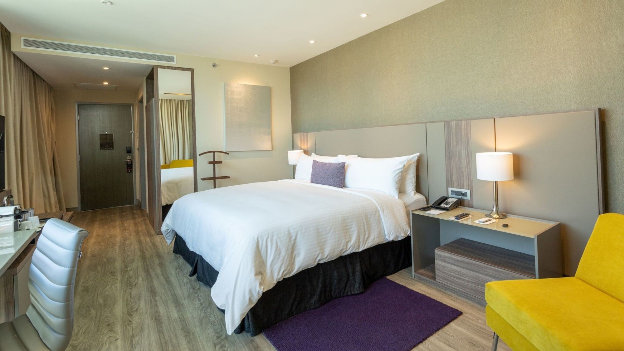 King Junior Suite with modern furnishings and yellow accent chairs at Camino Real Fashion Drive Monterrey