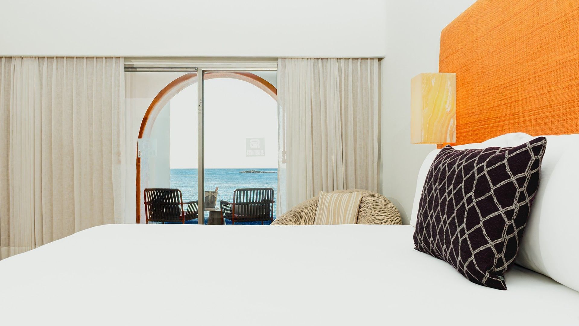 Cozy lounge chair by the bed in King Camino Real Club with balcony seating area at Camino Real Zaashila Huatulco