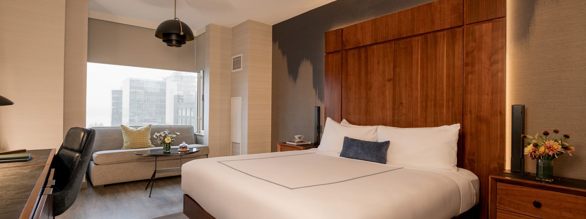 Grand Deluxe Room with large bed, sofa, and cityscape view at Gansevoort Meatpacking NYC in New York.
