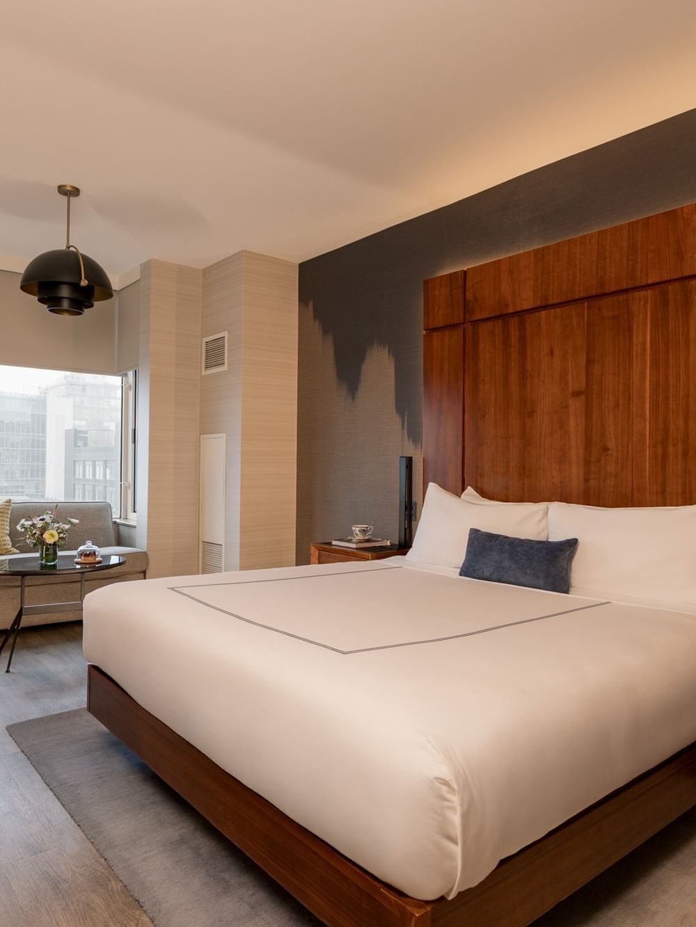Grand Deluxe Room with king bed, wooden headboard, seating area, and city views at Gansevoort Meatpacking NYC - NEW