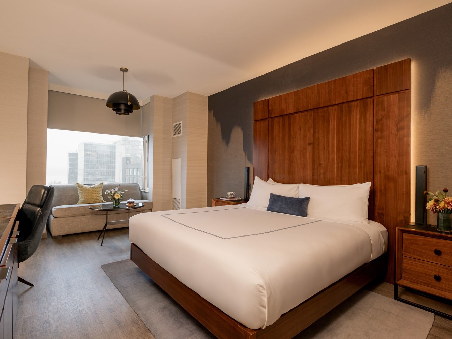 Grand Deluxe Room with large bed, sofa, and cityscape view at Gansevoort Meatpacking NYC in New York.