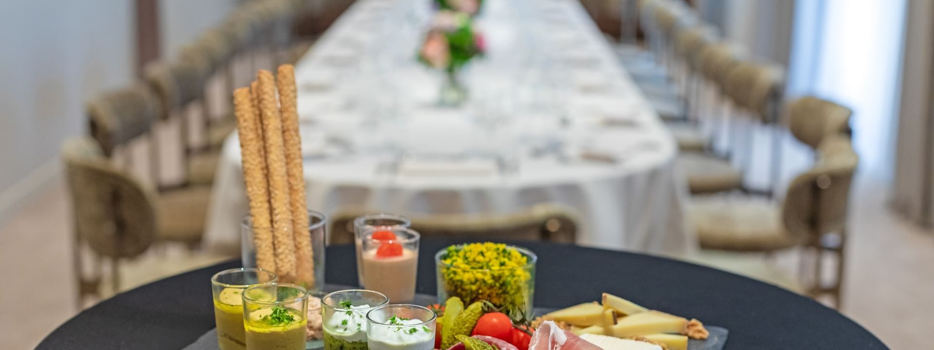 Slate platter with assorted appetizers & blurred dining table in the background in Windsor at Warwick Reine Astrid - Lyon