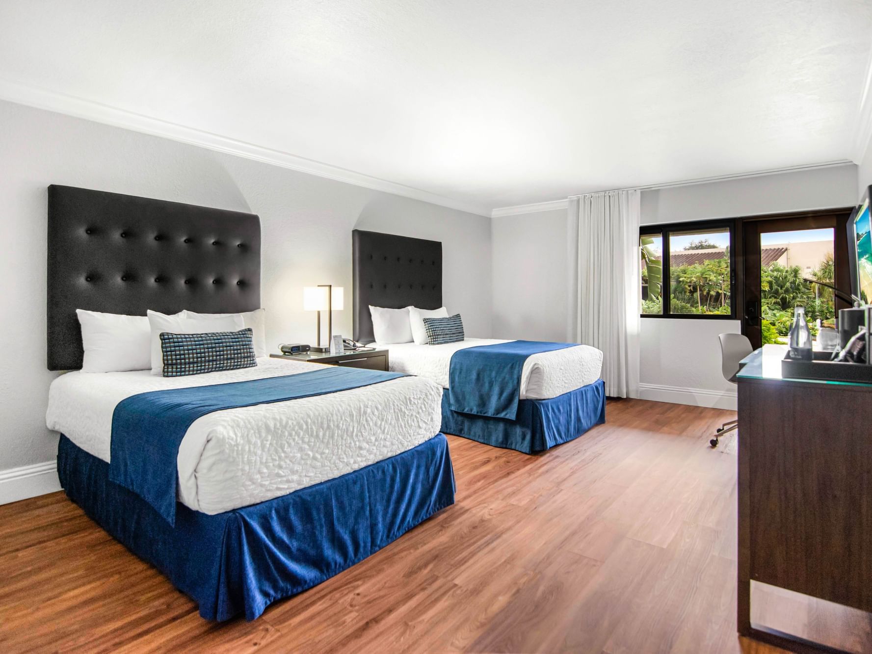 Double beds and work area in Pool View Deluxe Room with wooden floors at Miami Lakes Hotel