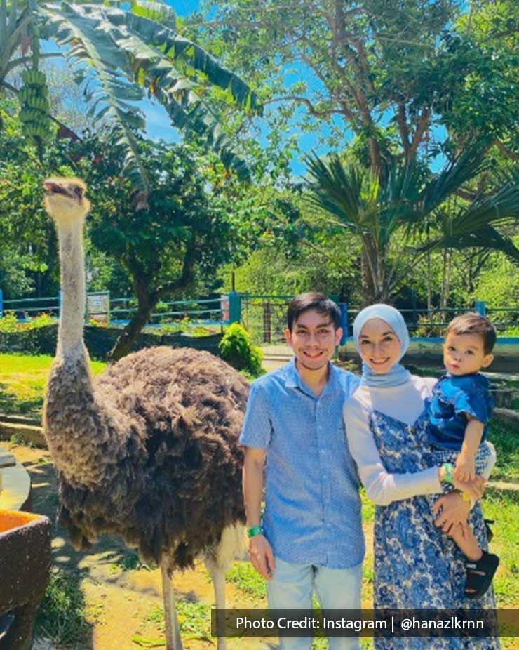 a family posing together with an ostrich