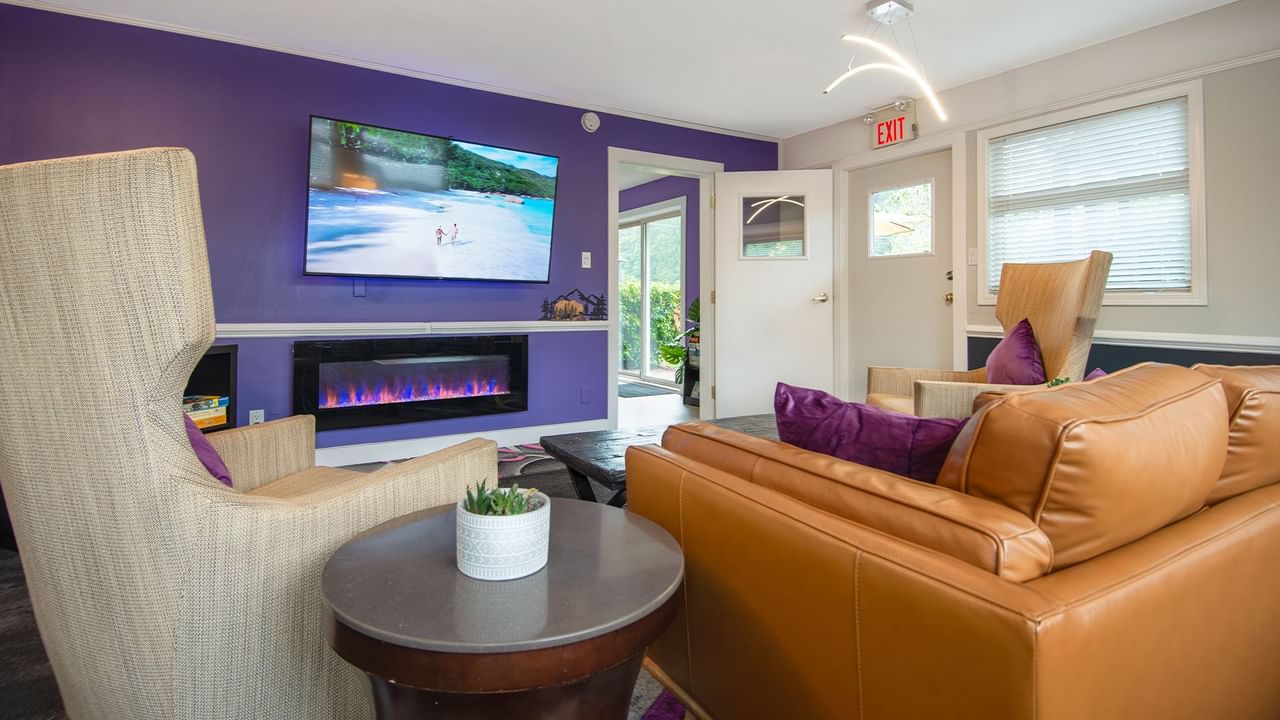 Lounge at Coast Parksville Hotel with chairs, tables and TV