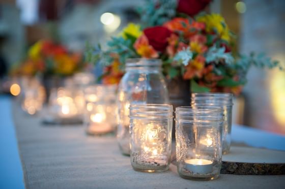 candles inside mason jars centered on table